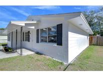 White house exterior with black shutters and small porch at 5836 8Th St, Zephyrhills, FL 33542