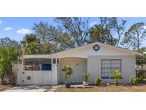 Charming brick home with a white picket fence and landscaped yard at 6811 S Hesperides St, Tampa, FL 33616