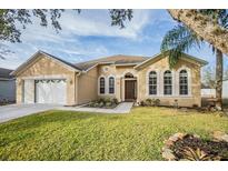 House exterior featuring a two-car garage and well-manicured lawn at 13029 Haverhill Dr, Spring Hill, FL 34609
