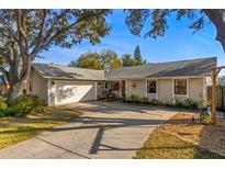 Tan house with a two-car garage and landscaped yard at 53 Turnstone Dr, Safety Harbor, FL 34695