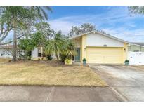 Attractive single-story home with a yellow garage and well-maintained lawn at 12331 Wild Acres Rd, Largo, FL 33773