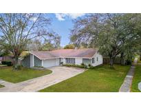 Charming single-story home featuring a well-maintained lawn, mature trees, and a welcoming curb appeal at 1712 Blind Pond Ave, Lutz, FL 33549