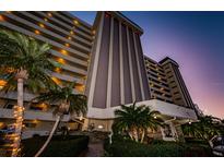 Attractive beachfront building at dusk, showcasing its architectural details and landscaping at 4550 Cove Cir # 804, St Petersburg, FL 33708