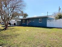 Charming single story blue home featuring a covered carport and spacious front yard at 11032 108Th Ave, Largo, FL 33778