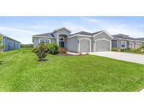 Two-car garage, well-manicured lawn, and attractive landscaping at 16120 67Th E Ct, Parrish, FL 34219