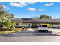 Front view of charming villa with carport and lush landscaping at 220 Dale Pl, Oldsmar, FL 34677
