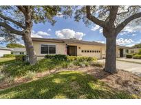 Tan single story home with mature landscaping and a two-car garage at 2510 Lancaster Dr # 166, Sun City Center, FL 33573