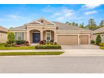 Beautiful one-story home with a three-car garage, landscaped yard, and a welcoming front porch at 4041 Woodland Retreat Blvd, New Port Richey, FL 34655