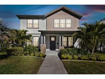 Two-story house with gray and beige siding, a stone base, and a walkway at 4909 4Th N Ave, St Petersburg, FL 33710