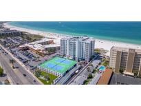 Aerial view of beachfront property with tennis courts and pool at 4950 Gulf Blvd # 401, St Pete Beach, FL 33706