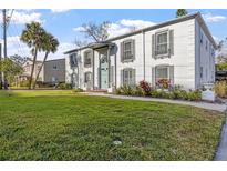 Two-story white brick building with green door, landscaping, and ample lawn at 1330 Snell Isle Ne Blvd # 4, St Petersburg, FL 33704