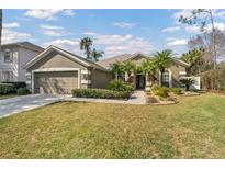 One-story home with landscaped yard, attached garage, and attractive curb appeal at 27544 Kirkwood Cir, Wesley Chapel, FL 33544