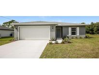 Gray house with white garage door and landscaping at 5127 Tower St, North Port, FL 34291