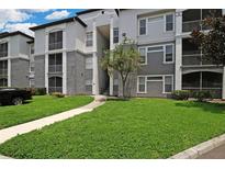 Exterior view of a condo building with landscaping and a walkway at 5511 Legacy Crescent Pl # 204, Riverview, FL 33578