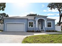 Newly constructed one-story home with light blue exterior, two car garage, and manicured lawn at 5575 113Th St, Seminole, FL 33772