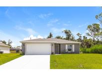 Newly constructed home with gray exterior, white garage door, and grassy lawn at 849 Haleybury St, Port Charlotte, FL 33948
