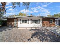 Mid-century modern home with white brick and wood siding at 1916 E Clinton St, Tampa, FL 33610