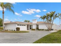 Modern single-story home with paved driveway and palm trees at 280 N Julia Cir, St Pete Beach, FL 33706