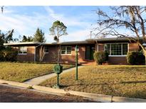 Brick ranch house with a green door, landscaped lawn, and a brick walkway at 36847 Jefferson Ave, Dade City, FL 33523