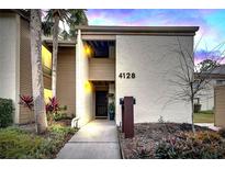 Inviting condo exterior with walkway, landscaping, and updated entryway at 4128 Pinelake Ln # 101, Tampa, FL 33618