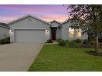 Curb appeal abounds in this charming one-story home, featuring a two-car garage and manicured lawn at 711 Old Windsor Way, Spring Hill, FL 34609