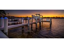 Private dock with boat lift, illuminated at sunset at 743 Chesapeake Dr, Tarpon Springs, FL 34689