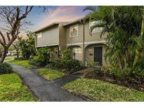 Tan two-story townhome with a landscaped front yard at 7606 Woodbridge Blvd, Tampa, FL 33615