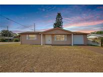 Charming ranch home with a well-maintained lawn and attached garage at 9005 Hunt Club Ln, Port Richey, FL 34668