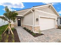 Single-story home with a two-car garage and landscaped walkway at 11498 Boundless Ter, Venice, FL 34293
