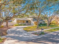 Two-story house with gray siding, a large yard, and mature trees at 14214 Lark Ct, Clearwater, FL 33762