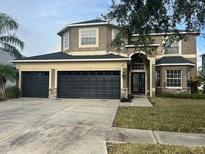 Two-story house with three-car garage and landscaped lawn at 19029 Chislehurst Dr, Land O Lakes, FL 34638