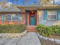 Inviting front entrance with teal door and brick columns at 2446 Belleair Rd, Clearwater, FL 33764