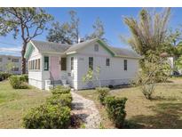 Charming home with a pathway leading to a pastel painted exterior and lush front yard landscaping at 2755 Edwards S Ave, St Petersburg, FL 33705