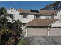 Two-story house with a two-car garage and solar panels at 3145 Meta Ct, Largo, FL 33771