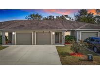 Triple-unit building with attached garages and landscaping at 37804 Prairie Rose Loop, Zephyrhills, FL 33542