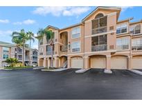 Exterior view of condo building with parking and landscaping at 1203 Bay Club Cir # 1203, Tampa, FL 33607