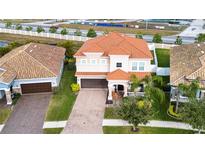 Two-story house with tile roof, driveway, and landscaping at 13144 Green Violet Dr, Riverview, FL 33579