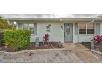 Front view of a charming light-colored home with gray door and landscaping at 210 Gloucester Blvd, Sun City Center, FL 33573