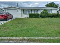 Ranch-style home with a spacious yard and a single-car garage at 4031 Cluster Dr, Holiday, FL 34691