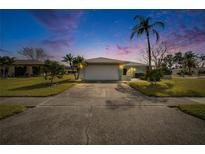 Inviting house exterior at dusk, featuring a two-car garage and well-manicured lawn at 4188 104Th N Ave, Clearwater, FL 33762