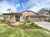 Single-story home with attractive landscaping and a three-car garage at 4739 Belden Cir, Palm Harbor, FL 34685