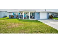 Cute ranch home with circular driveway, carport, and landscaped lawn at 5040 Victoria Ln, Holiday, FL 34690