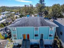 Aerial view of a teal three-unit building with individual garages at 639 Michigan Blvd, Dunedin, FL 34698