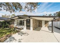 Mid-century modern home with stone accents and carport at 7007 N Hubert Ave, Tampa, FL 33614