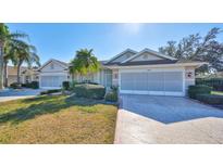 Front view of charming villa with two-car garage and landscaped lawn at 1006 Mcdaniel St # 21, Sun City Center, FL 33573
