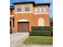 Two-story house with brown garage door and manicured hedges at 1028 Tullamore Dr, Wesley Chapel, FL 33543