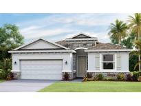 Two-story house with a stone facade, light gray siding, and a two-car garage at 10822 Patoka Ter, Parrish, FL 34219