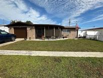 Ranch-style home with a well-maintained lawn and a screened porch at 2152 Arcadia Rd, Holiday, FL 34690