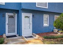 Two-unit building with blue exterior, gray doors, and landscaping at 3327 Fox Hunt Dr, Palm Harbor, FL 34683