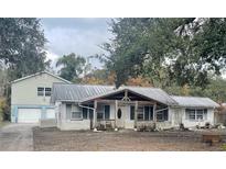 Ranch-style home with metal roof and detached garage at 34799 Evergreen Way, Dade City, FL 33523